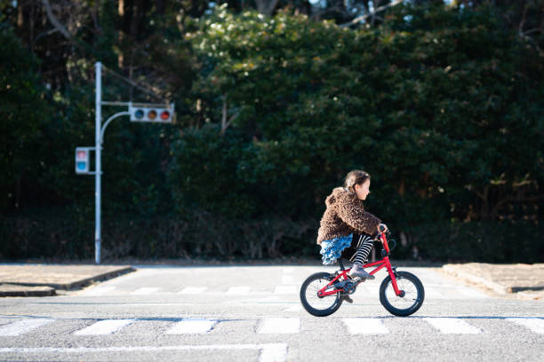 Girl across the intersection by bicycle