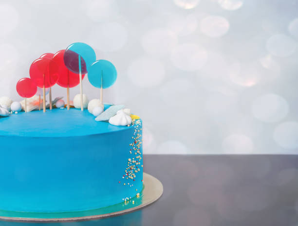 istock Blue buttercream Birthday cake with colorful lollipops. 1127565305