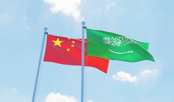 istock Saudi Arabia and China, two flags waving against blue sky 1127565469