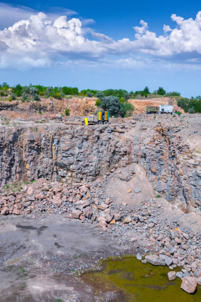 istock Spectacular view of quarry open pit mining of granite stone. Process production stone and gravel. Quarry mining equipment. Groundwater in the quarry. 1127565571