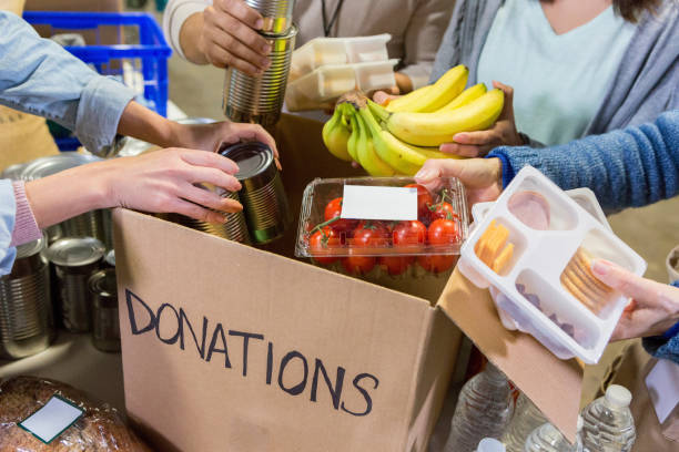 istock Unrecognizable food bank volunteers unpack donation box 1127566187