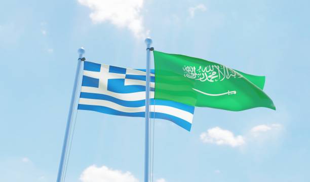 istock Saudi Arabia and Greece, two flags waving against blue sky 1127566228
