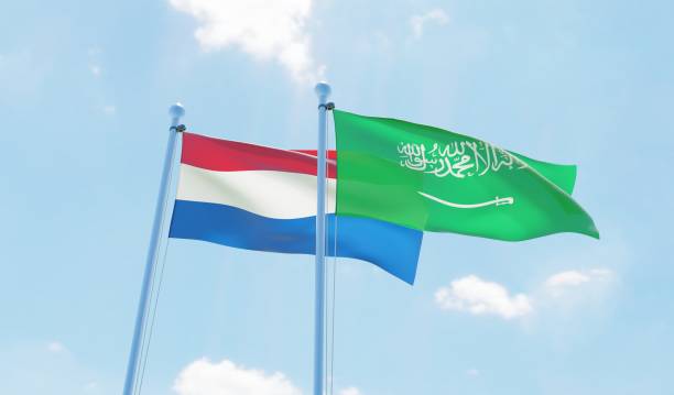istock Saudi Arabia and Netherlands, two flags waving against blue sky 1127567639
