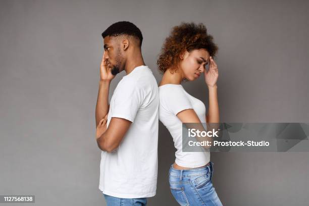 Upset Couple Standing Back To Back On Gray Background Stock Photo - Download Image Now