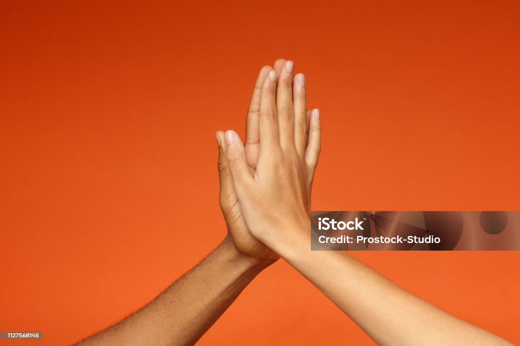 Hombre y mujer saludándose con cinco altos - Foto de stock de Choque de manos en el aire libre de derechos