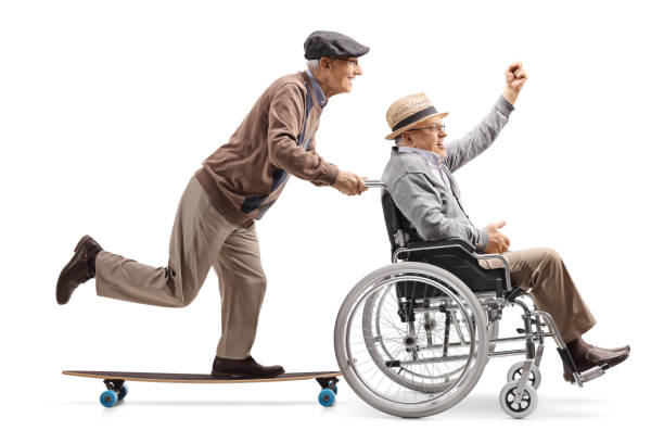 vieil homme sur un longboard pousser un homme à main levée dans un fauteuil roulant - physical injury men orthopedic equipment isolated on white photos et images de collection