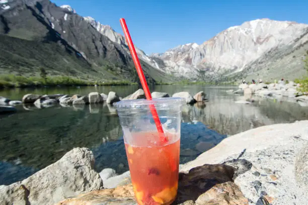 Fruity tea drink placed in front of Convict Lake located off of US-395, near Mammoth Lakes California in the eastern Sierra Nevada mountains,