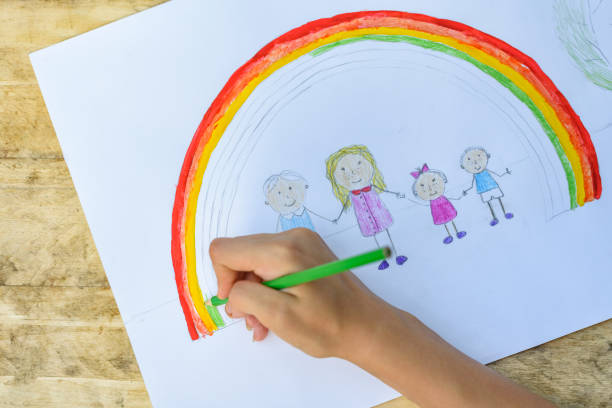 istock Children's hands paint a drawing with a brush and paints. Top view 1127572270