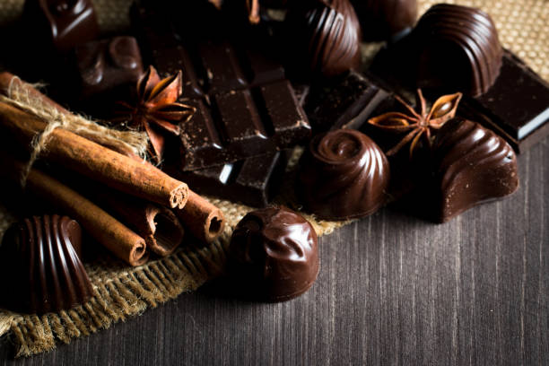 istock Assortment of dark, white and milk chocolate stack, chips. Chocolate and coffee beans on rustic wooden sacking background. Spices, cinnamon. Selective macro focus. Chocolates background. Sweets 1127572388