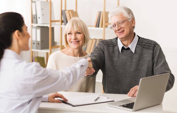 istock Thankful senior patient shaking hands with doctor 1127572895
