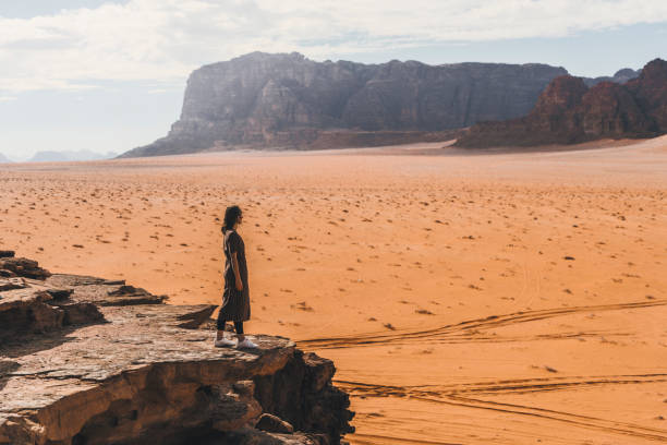 istock Woman looking at  Wadi Rum desert from rock 1127574287
