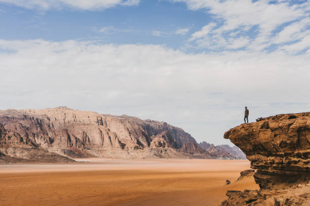 donna che guarda il deserto del wadi rum dalla roccia - wadi rum foto e immagini stock