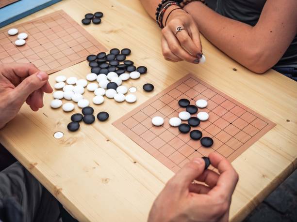 istock People playing chinese boardgame. People Playing Mahjong Asian Tile-based Game. Table Gambling top viewThe game of go view from above. 1127576465