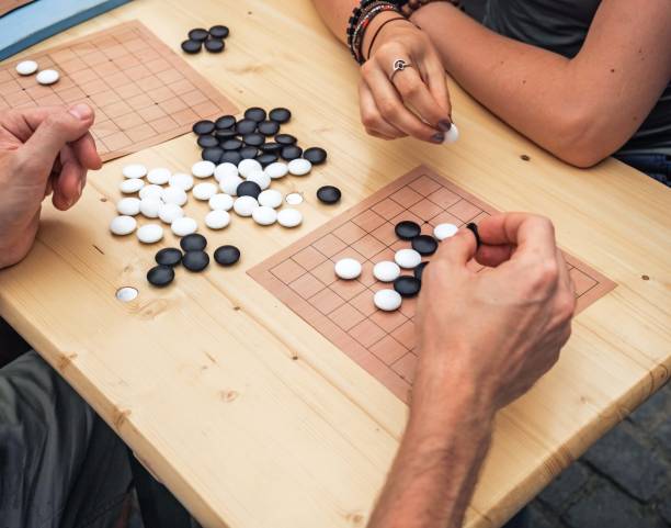 istock People playing chinese boardgame. People Playing Mahjong Asian Tile-based Game. Table Gambling top viewThe game of go view from above. 1127576475