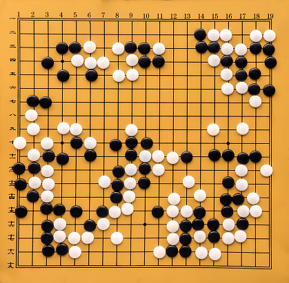 Top view on a Go board. Desk for board game Go and black and white bones. Traditional asian strategy board game. Atomic Bomb Game. The game of go view from above..