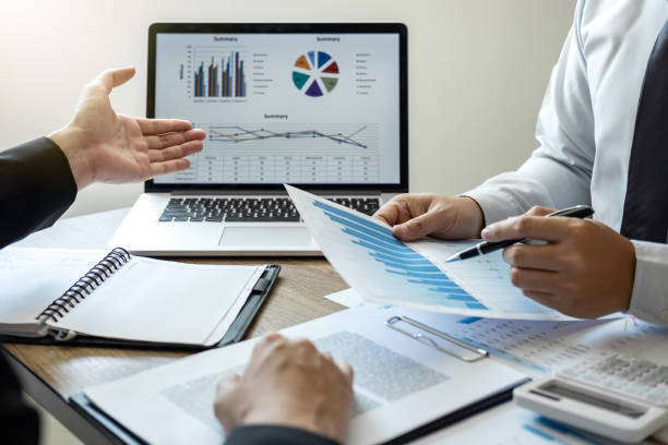 istock Midsection Of Business People Analyzing Graphs At Desk 1127577078