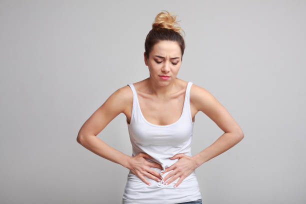 istock Woman with stomachache, having food poisoning, grey background 1127578521