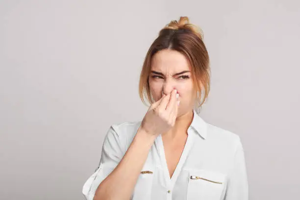 Photo of Woman closing nose because of bad smell