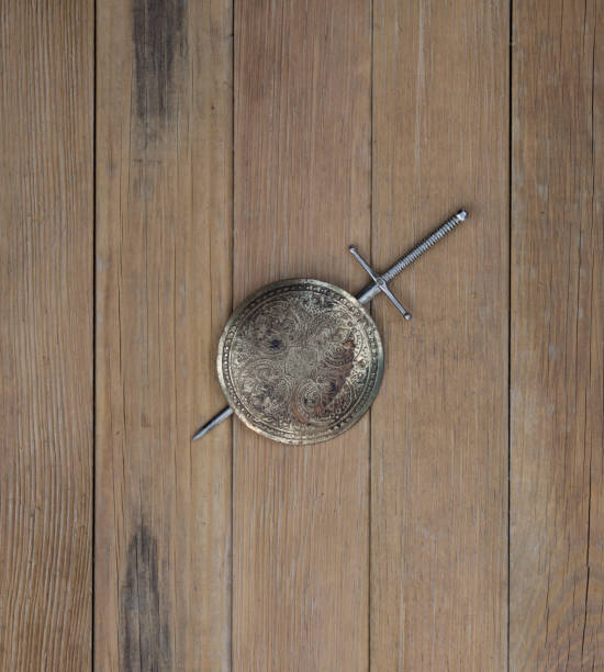 istock sword and shield on wooden background 1127579211