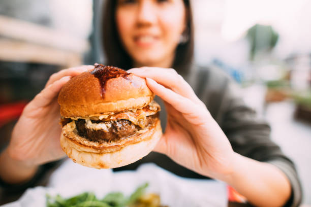 istock Woman eating beef burger 1127579845