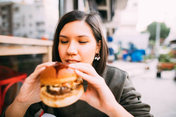 istock Woman eating beef burger 1127580472