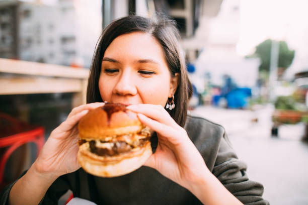 istock Woman eating beef burger 1127580506