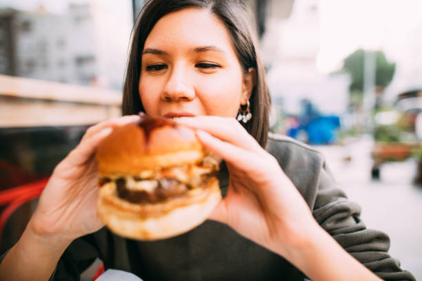 istock Woman eating beef burger 1127580591