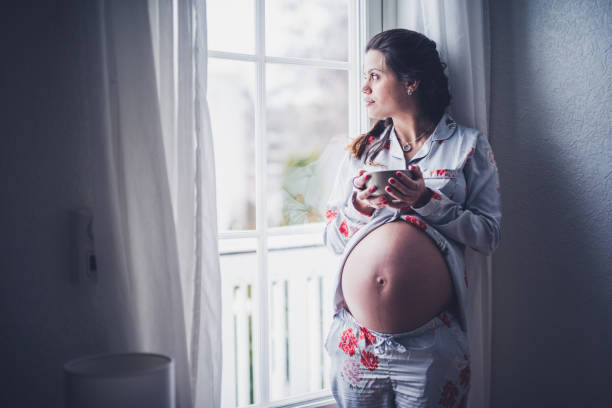 istock Serious pregnant female drinking coffee. 1127580871