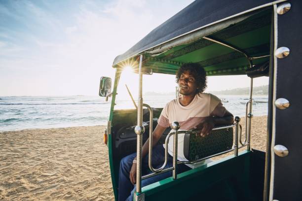 Portrait of tuk tuk driver Young tuk tuk driver waiting for passenger against sand beach and sea in Sri Lanka. taxi sri lanka stock pictures, royalty-free photos & images