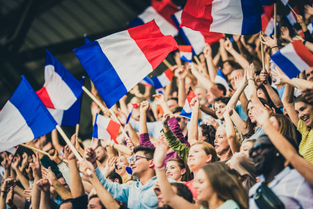 Large crowds of French sports fans waving their flags on a stadium.
