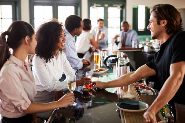 istock Bartender Serving Two Businesswomen Meeting For After Works Drinks 1127582283
