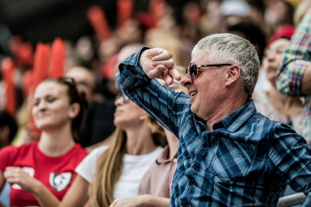 istock Mature man with sunglasses in a stadium crowd 1127582532