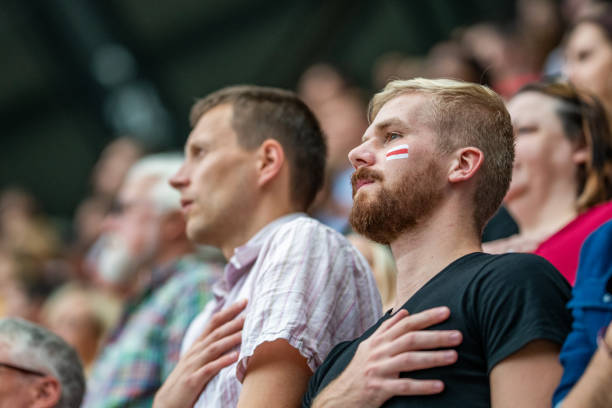istock People with hands on their hearts during the national anthem 1127582546