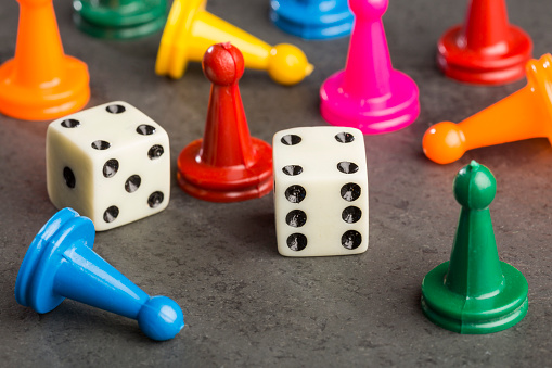 Game pieces with dices on slate