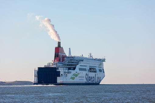 Hoek van Holland, the Netherlands - January 20 2019: car passenger ferry ship Stena Line sailing out of port Rotterdam past Hoek van Holland with smoke and steam coming out of funnel