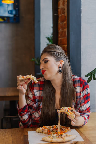 istock sitting by the window in a cafe and eating pizza 1127586733
