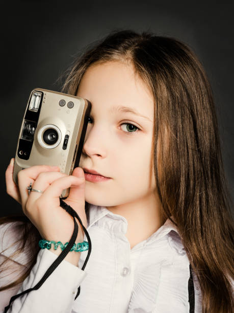 piccola bella ragazza con una vecchia macchina fotografica. giovane fotografo - girl sunglasses 80s foto e immagini stock