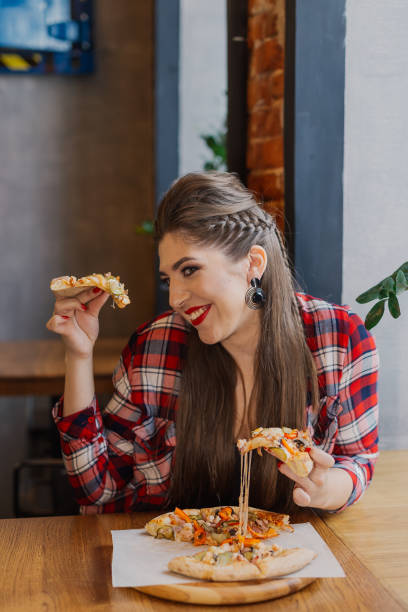 istock sitting by the window in a cafe and eating pizza 1127586779