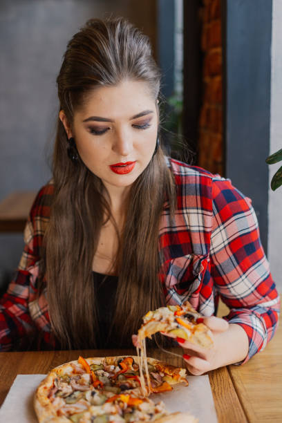 istock sitting by the window in a cafe and eating pizza 1127586814