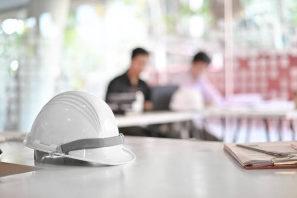 istock Architectural Office desk construction project with drawing equipment and engineer helmet. 1127589480