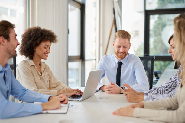 istock Small group of business people sitting at table and doing brainstorming. 1127590130