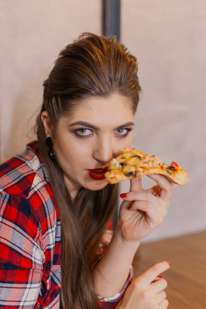 istock Girl sitting at a table with a pizza in a cafe 1127590260