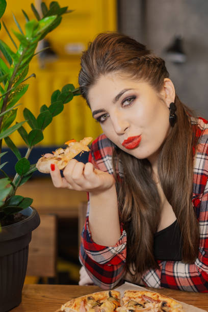 istock Girl sitting at a table with a pizza in a cafe 1127591244
