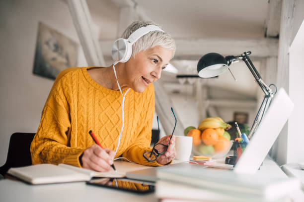 istock Woman with headphones writing 1127591798