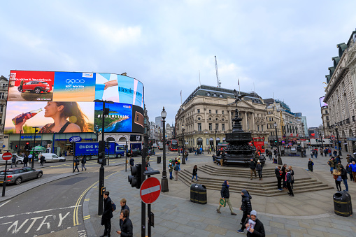 London, United Kingdom - Feb 22, 2018: Tourists visiting London, in front of Piccadilly Circus
