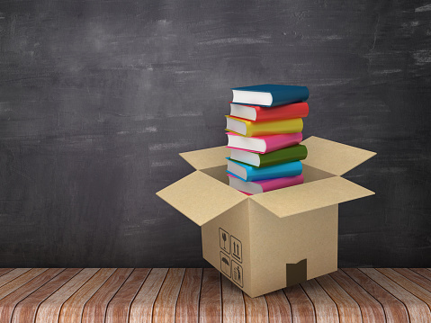 Cardboard Box with Books on Wood Floor - Chalkboard Background - 3D Rendering