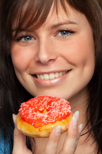 istock Donuts fun; Attractive Young Woman with one pink Iced Donuts 1127596358