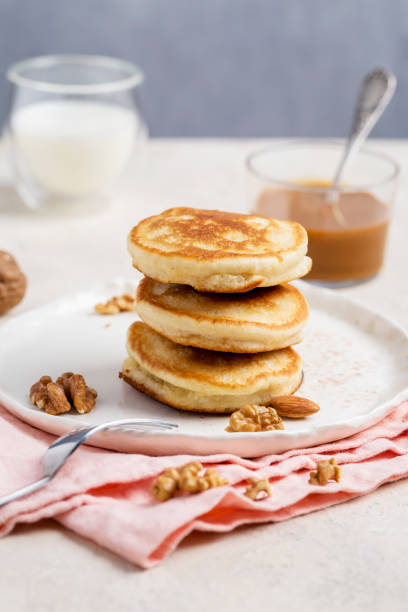 istock American pancakes with nuts at white plate with fork and napkin 1127597534