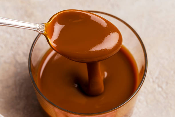 istock Spoon with caramel in glass jar, close up 1127597567