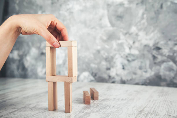 istock woman hand wooden cubes on table 1127604377